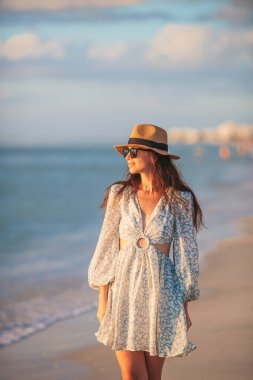 Young beautiful woman on vacation at sunset