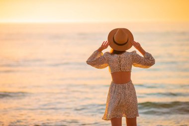 Young beautiful woman on vacation at sunset