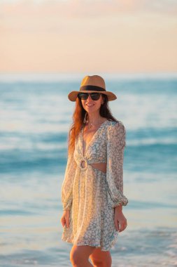 Young beautiful woman on vacation at sunset