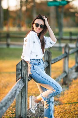 Happy young woman outdoor in the park at sunset. High quality photo