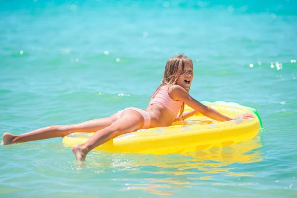 Adorable girl with inflatable air mattress in the sea