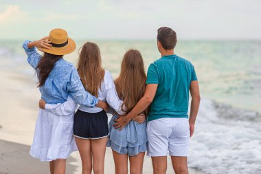 İki çocuklu ebeveynler kumsalda birlikte eğleniyorlar.