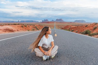 Scenic highway in Monument Valley Tribal Park in Utah. Happy girl on famous road in Monument Valley in Utah.  clipart