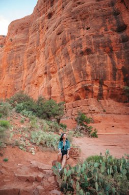 Sedona, Arizona 'daki Katedral Rock' ta yürüyüş yapan genç bir kadın. Arizona 'da mavi gökyüzü olan Sedona' daki Scenic Cathedral Rock 'tan görüntü