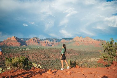 Sedona, Arizona 'daki Katedral Rock' ta yürüyüş yapan genç bir kadın. Arizona 'da mavi gökyüzü olan Sedona' daki Scenic Cathedral Rock 'tan görüntü