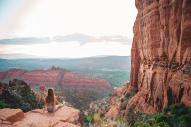 Sedona, Arizona 'da gün batımında Katedral Rock' ın kenarındaki küçük kızın arka görüntüsü. Arizona 'da mavi gökyüzü olan Sedona' daki Scenic Cathedral Rock 'tan görüntü