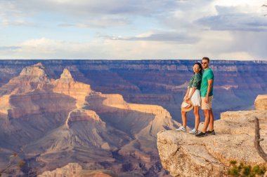 Dik bir uçurumda genç bir çift. Muhteşem manzarası olan ünlü Büyük Kanyon üzerinde güzel bir günbatımı, Büyük Kanyon Ulusal Parkı, Arizona. Yüksek kalite fotoğraf