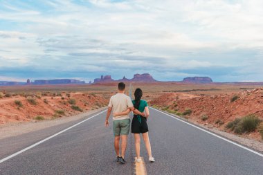 Utah 'taki Monument Valley Kabile Parkı' nda manzara otoyolu. Anıt Vadisi 'ndeki ünlü yolda genç bir aile. Anıt vadisinin muhteşem manzarası.