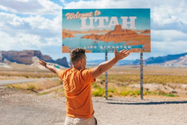 Amerika 'ya seyahatte olan mutlu adam, ABD' deki Ulusal Kanyon 'daki Utah Eyalet Sınır Tabelasına hoş geldiniz.