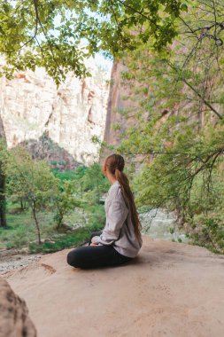 Sevimli genç kız Zion Ulusal Parkı 'nda Utah State, ABD' deki nehir manzaralı yolda dinleniyor.