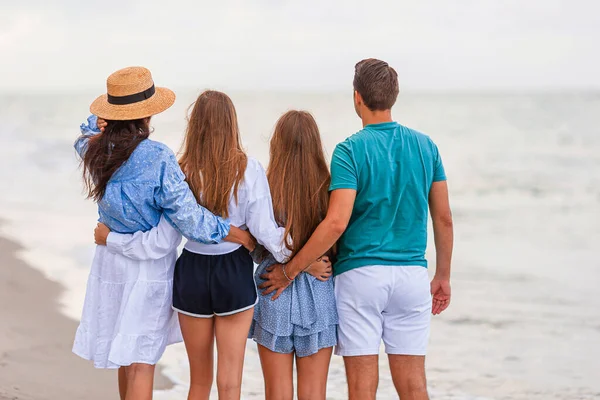两个父母和两个可爱的少女在海滩度假时一起散步的画像 — 图库照片