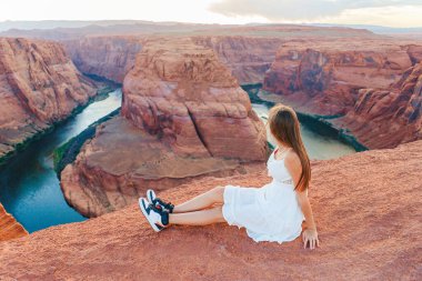 Colorado Nehri, Arizona 'nın muhteşem manzaralı Page Canyon' daki ünlü Horseshoe Bend 'deki mutlu kız. Macera ve turizm konsepti.