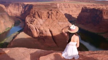 Uçurumun kenarında beyaz elbiseli genç bir kız. At nalı bandı kanyonu. Macera ve turizm konsepti. Yüksek kalite fotoğraf