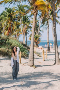 Palmiye ağacının yanındaki tropik plajda güzel bir kadın. Yüksek kalite fotoğraf