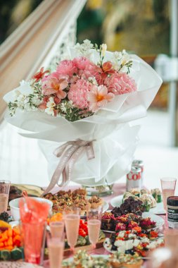 Vazodaki düğün masasının üzerinde parlak, güzel bir buket şakayık. Yüksek kalite fotoğraf