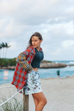 Şortlu ve plajda kareli gömlekli mutlu kız. Yüksek kalite fotoğraf