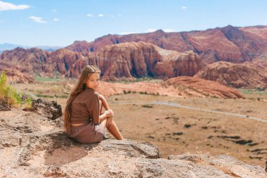 Nevada Eyalet Parkı 'ndaki Ateş Vadisi' nde dağların arasından yürüyüşe hazır genç bir kızın arka görüntüsü.