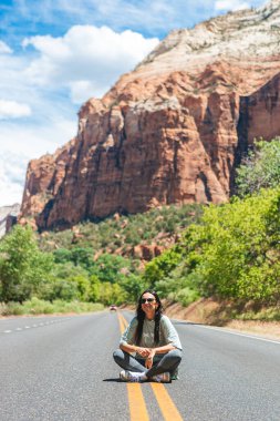 Happy girl on the road in Zion national park. Amazing view of the valley. High quality photo clipart