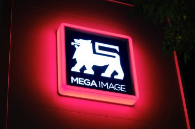 Geceleri aydınlatılmış Mega Image logosu işareti. Mega Image, Romanya 'da 1995 yılında kurulan ve sahibi Ahold Delhaize olan bir süpermarket zinciri. Bükreş, Romanya - 2 Ekim 2022.