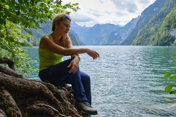Almanya, Bavyera 'da Konigssee Gölü kıyısında dalgın bir kadın. Ruh hali, portre, doğa, açık hava, meditasyon, iç gözlem, meditasyon, sakin, düşünceli, içe dönük.