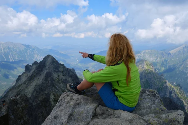 Kadın yürüyüşçü parmağını Slovakya 'daki High Tatras dağlarında bir zirveye doğrultuyor. Yürüyüş, yürüyüş, macera, aktif, aktivite, doğa.