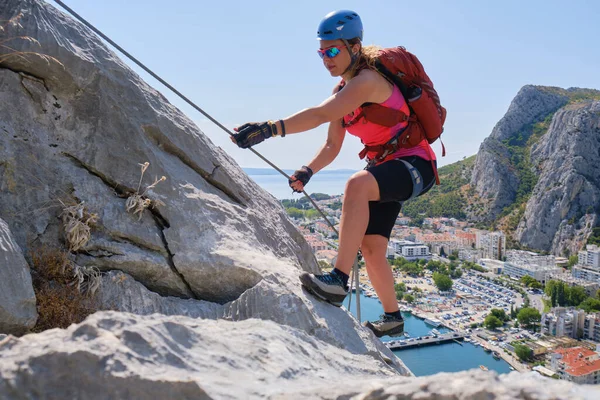 女人通过克罗地亚Omis市上空的Ferrata Fortica爬上山顶 攀登者 冒险者 活跃分子 免版税图库图片