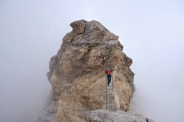 Женщина Поднимается Лестнице Ферраты Скалистом Хребте Покрытом Туманом Тофана Меццо — стоковое фото