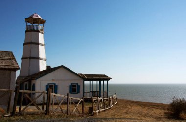 Autumn October photo lighthouse on the seashore. clipart