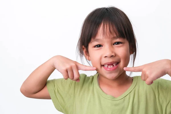 上の乳歯と最初の永久歯を骨折したアジアの女の子の肖像画 フレンドリーな女の子ショー彼女の壊れた歯絶縁上の白い背景 — ストック写真