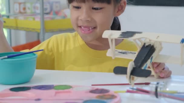 Portrét Šťastné Asijské Dívky Malbou Štětcem Dřevěném Letadle Učebně Umění — Stock video