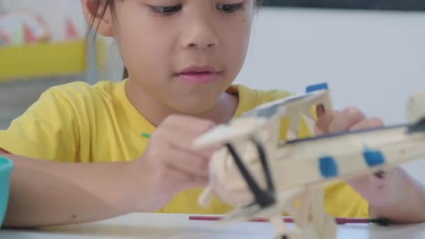 Porträtt Glad Asiatisk Flicka Med Penselmålning Ett Leksaksplan Trä Klassrummet — Stockvideo