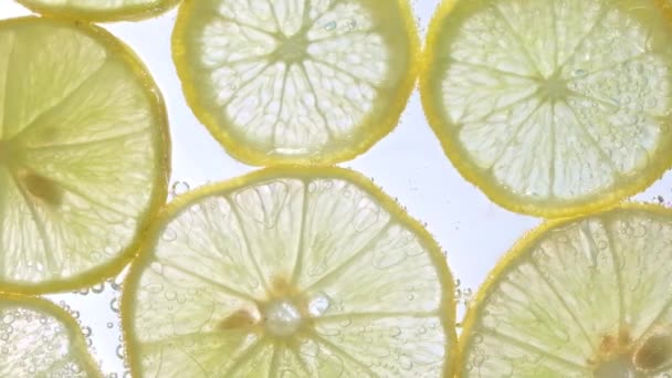 Saftiga Citronskivor Med Bubblor Vatten Isolerad Vit Bakgrund Gul Lime — Stockvideo