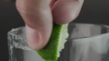 Erkek el, mutfaktaki tahta kesme tahtasının üzerinde bıçakla limonu ikiye bölüyor. Bıçakla dilimlenmiş taze limon meyvesi..