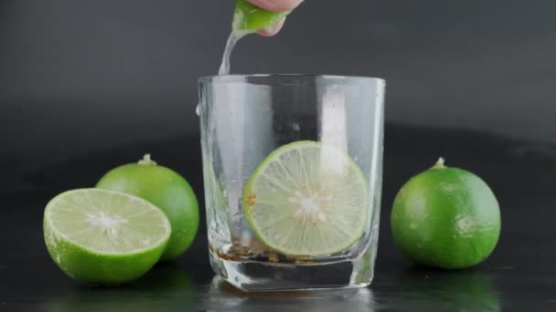 Mano Spremendo Calce Bicchiere Con Fette Ghiaccio Limone Con Lime — Video Stock