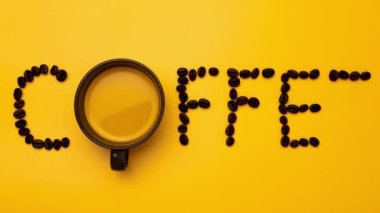 Kahve çekirdekli kahve fincanının içindeki siyah kahvenin sarı arkaplanda kahve mesajı yapmasını durdur..