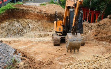 İnşaat alanındaki bir sürüngen kazıcısının ön görüntüsü. Çukur temelini kazmak.
