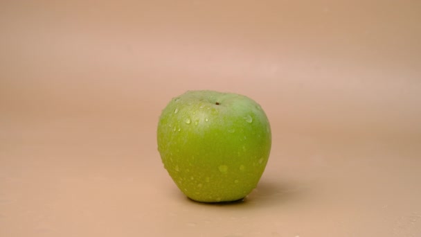 米色背景下新鲜青苹果上的慢动作水花 — 图库视频影像