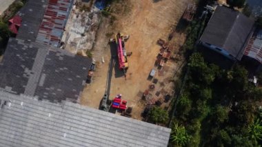 Mobile crane stands waiting to lift steel at a warehouse. Crane operators and mobile cranes working at a construction site.