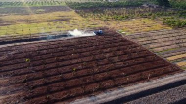 Aerial view of a wheel loader excavator with a backhoe loading sand into a heavy earthmover at a construction site. Excavator digging soil pits for the agricultural industry.