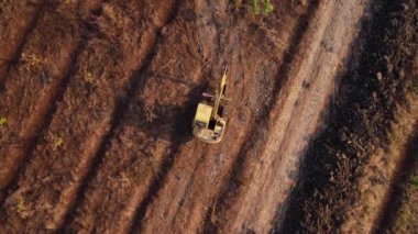 Excavator dig ground at construction site. Aerial view of a wheel loader excavator with a backhoe loading sand into a heavy earthmover. Excavator digging soil pits for the agricultural industry.