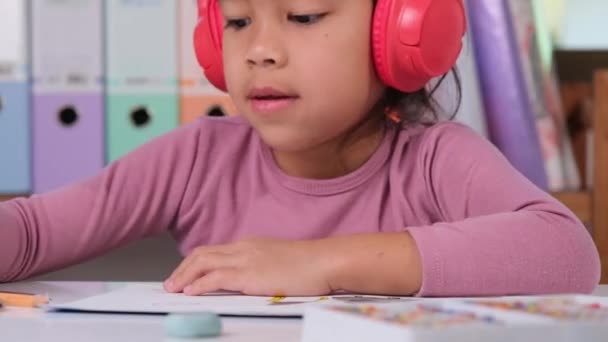 Kulaklıklı Neşeli Küçük Bir Kız Evdeki Odasında Masasında Oturan Renkli — Stok video