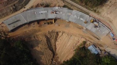 Yeni yol inşaatının ya da inşaat halindeki üstgeçitin havadan görünüşü. Dağların arasındaki yol inşaatçılarının üstündeki bir dronun üst görüntüsü..