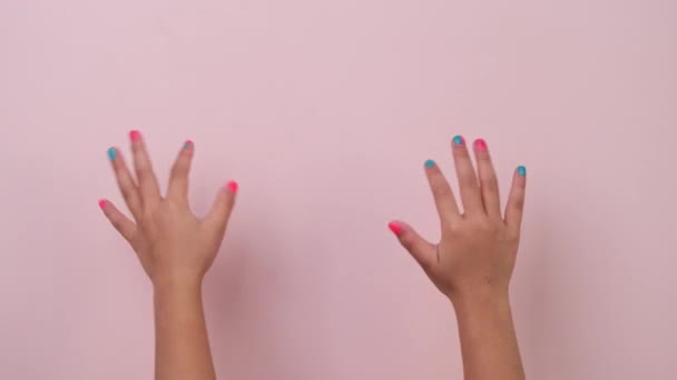 Großaufnahme Der Erhobenen Kinderhand Die Nagellack Zeigt Und Auf Pastellrosa — Stockvideo