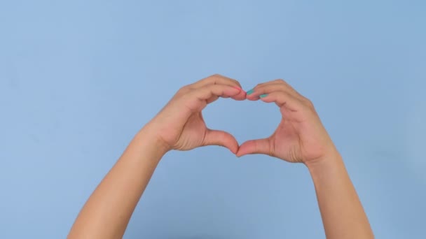 Kobieta Ręka Pokazuje Kształt Serca Miłości Sympatii Symbol Pastelowym Niebieskim — Wideo stockowe