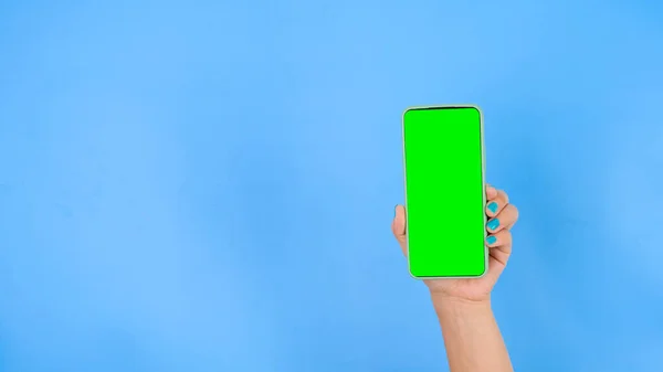 Mavi Arka Planda Yeşil Ekranlı Akıllı Telefonu Tutan Bir Kadın — Stok fotoğraf