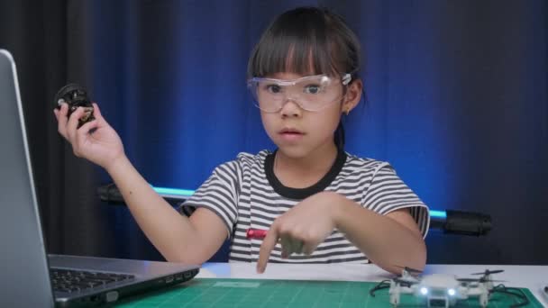 リトル サイエンティスト スクール プロジェクト 子供の修理を学ぶレッスンコントロールおもちゃドローンを取得します 家庭でのワークショップでネジおもちゃのドローンを修正するためにドライバを使用して幸せなアジアの女の子 Stem教育 — ストック動画