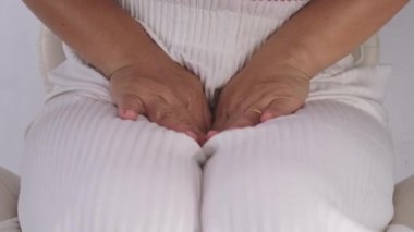 Elleri kasıklarında olan bir kadın beyaz arka planda izole edilmiş. Kadın eli kasığını pelvis ağrısı ya da vajinal kaşıntıyla tutuyor. Jinekolojik sorunlar. Sağlık hijyeni kavramı