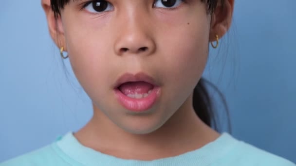 Gadis Kecil Lucu Mengunyah Permen Karet Latar Belakang Biru Potret — Stok Video