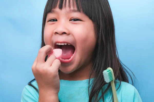 Χαμογελώντας Χαριτωμένο Κοριτσάκι Κρατώντας Οδοντόβουρτσα Και Γλυκά Απομονώνονται Μπλε Φόντο — Φωτογραφία Αρχείου