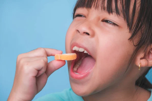 Χαμογελώντας Χαριτωμένο Κοριτσάκι Τρώει Γλυκιά Ζελατίνη Ζάχαρη Προστίθεται Απομονωμένο Μπλε — Φωτογραφία Αρχείου